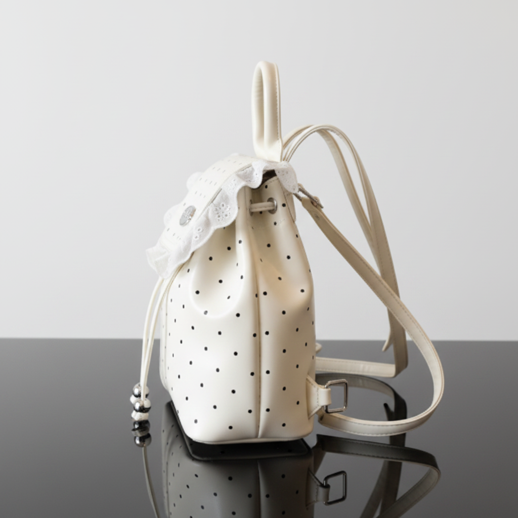 Polka Dot Lace Trim Backpack Bag side angle on black glass